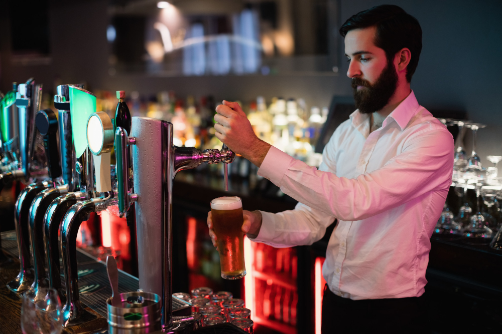 A skilled bartender pouring a cold beer at a stylish bar, highlighting premium services and event offerings.