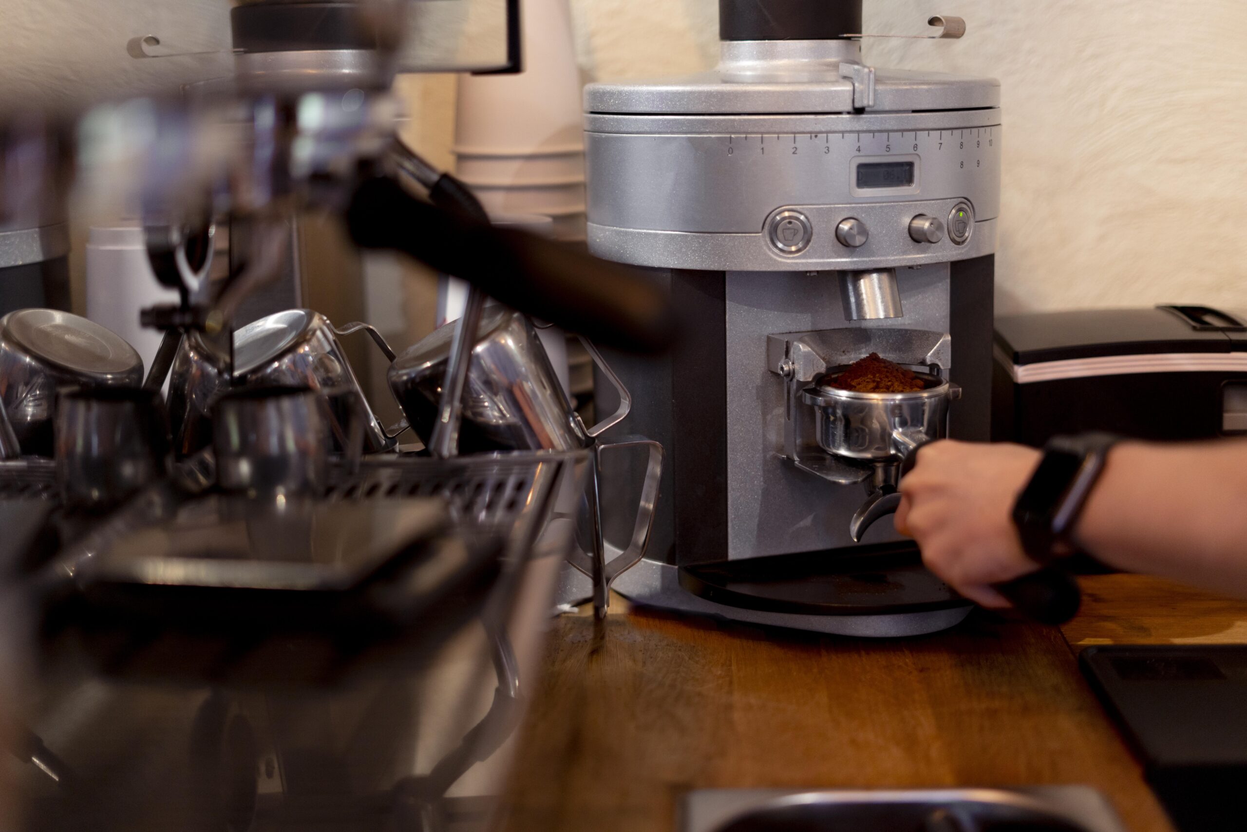 A person skillfully makes coffee at Premium Knoxville Roast Coffee Company, highlighting the café's inviting atmosphere.